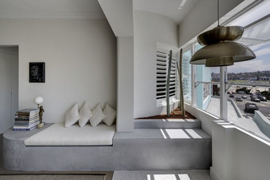 シドニーにある低価格の小さなコンテンポラリースタイルのおしゃれなリビング (白い壁、塗装フローリング、暖炉なし、埋込式メディアウォール、茶色い床) の写真