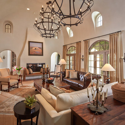 Inspiration for a mid-sized mediterranean formal and enclosed terra-cotta tile and red floor living room remodel in Houston with a two-sided fireplace, beige walls, a plaster fireplace and no tv