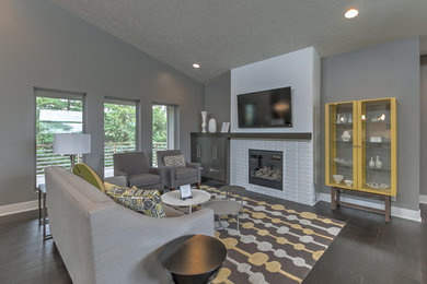 Example of a mid-sized minimalist open concept dark wood floor living room design in Other with gray walls, a standard fireplace, a tile fireplace and a wall-mounted tv