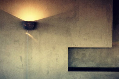 メルボルンにある中くらいなインダストリアルスタイルのおしゃれなリビングロフト (グレーの壁、コンクリートの暖炉まわり) の写真