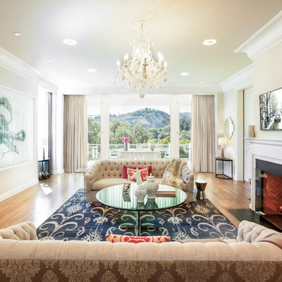 Living room - transitional medium tone wood floor living room idea in Los Angeles with beige walls and a standard fireplace