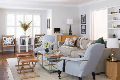 Living room library - traditional enclosed medium tone wood floor living room library idea in Los Angeles with gray walls