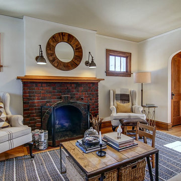 Brick fireplace flanked by matching grain sack upholstered wingbacks.