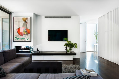 Imagen de salón abierto minimalista pequeño con paredes blancas, suelo de madera oscura y chimenea de doble cara
