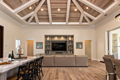 Imagen de salón abierto de estilo americano con suelo de madera en tonos medios y pared multimedia