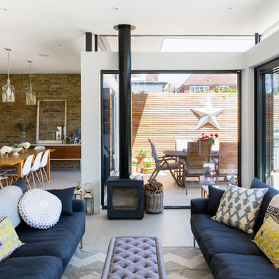 Example of a large trendy formal and open concept porcelain tile living room design in London with a wood stove and white walls
