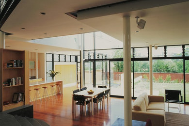 Ejemplo de salón actual con paredes blancas y suelo de madera en tonos medios