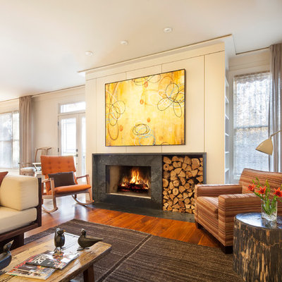 Inspiration for a mid-sized contemporary open concept medium tone wood floor and brown floor living room remodel in Atlanta with white walls, a standard fireplace, a stone fireplace and a wall-mounted tv