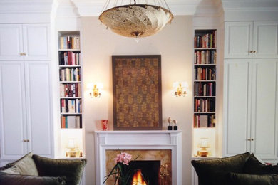 Living room library - large traditional enclosed medium tone wood floor living room library idea in New York with beige walls, a standard fireplace, a stone fireplace and a media wall