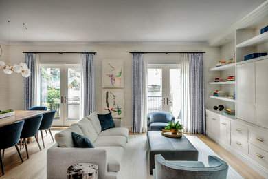 Mittelgroßes, Abgetrenntes Modernes Wohnzimmer mit grauer Wandfarbe, hellem Holzboden, verstecktem TV und grauem Boden