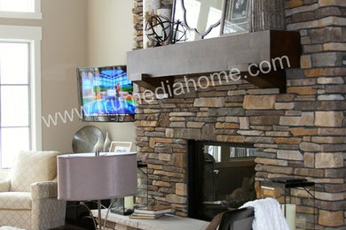 Mid-sized arts and crafts enclosed and formal dark wood floor living room photo in Grand Rapids with beige walls, a wall-mounted tv, a standard fireplace and a stone fireplace