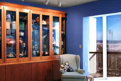 Modelo de salón para visitas cerrado contemporáneo de tamaño medio sin chimenea y televisor con paredes azules, suelo de madera clara y suelo marrón