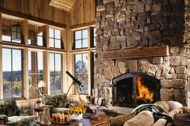 This is an example of a medium sized rustic formal enclosed living room in Denver with brown walls, light hardwood flooring, a standard fireplace, a stone fireplace surround, no tv and brown floors.