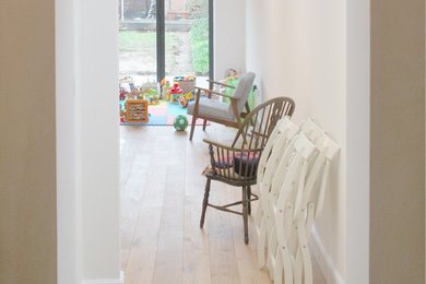 Ejemplo de salón abierto minimalista pequeño sin chimenea con paredes blancas, suelo de madera clara y suelo beige