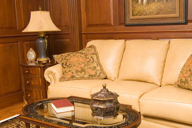 Example of a mid-sized classic enclosed medium tone wood floor and brown floor living room library design in Philadelphia with a standard fireplace and a wood fireplace surround
