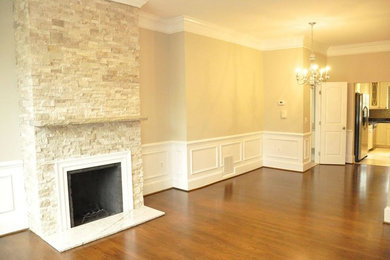 Foto de salón abierto contemporáneo de tamaño medio con paredes beige, suelo de madera en tonos medios, todas las chimeneas y marco de chimenea de piedra