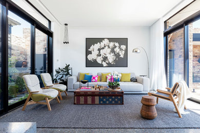 Idee per un soggiorno contemporaneo di medie dimensioni con pareti bianche, pavimento in cemento, cornice del camino in cemento e nessuna TV