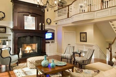 Example of a large transitional formal and open concept dark wood floor and brown floor living room design in Boston with beige walls, a standard fireplace, a stone fireplace and a wall-mounted tv