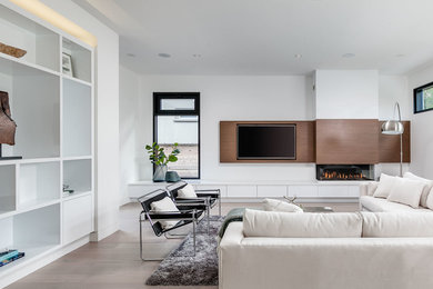 Großes, Offenes Modernes Wohnzimmer mit weißer Wandfarbe, hellem Holzboden, Gaskamin und Multimediawand in Sonstige