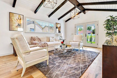 Medium sized traditional formal open plan living room in Los Angeles with white walls, light hardwood flooring, a standard fireplace, a concrete fireplace surround, no tv and beige floors.