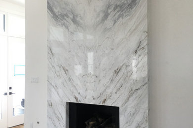 広いトランジショナルスタイルのおしゃれなリビング (白い壁、濃色無垢フローリング、標準型暖炉、石材の暖炉まわり) の写真