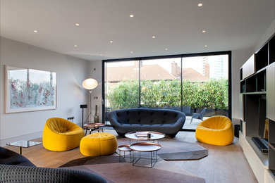 Mittelgroßes, Repräsentatives, Offenes Modernes Wohnzimmer mit weißer Wandfarbe, braunem Holzboden und freistehendem TV in London