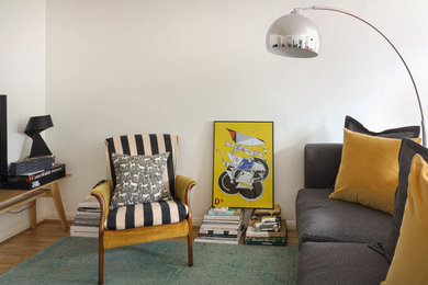 Imagen de salón abierto retro de tamaño medio con paredes blancas y suelo de madera en tonos medios
