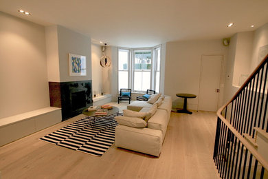 Design ideas for a contemporary living room in London with light hardwood flooring.