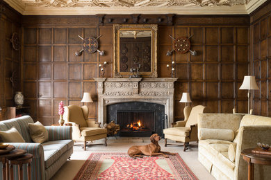 ロンドンにある広いトラディショナルスタイルのおしゃれな独立型リビング (茶色い壁、カーペット敷き、標準型暖炉、金属の暖炉まわり、ベージュの床) の写真