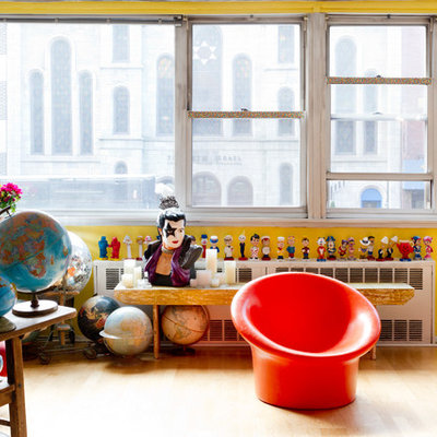 Example of an eclectic enclosed living room design in New York with yellow walls