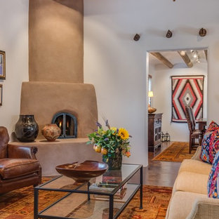 Example of a mid-sized southwest formal and enclosed concrete floor and brown floor living room design in Albuquerque with white walls, a corner fireplace, a plaster fireplace and no tv