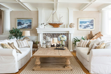Repräsentatives Maritimes Wohnzimmer mit beiger Wandfarbe, braunem Holzboden, Kamin und Kaminumrandung aus Stein in Portland Maine