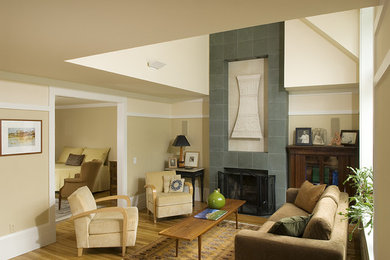 Example of a mid-sized trendy enclosed medium tone wood floor living room design in Boston with beige walls, a standard fireplace and a stone fireplace