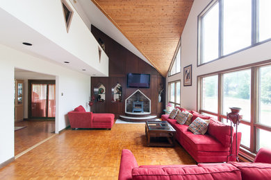 Ejemplo de salón abierto clásico grande sin televisor con paredes blancas, suelo de madera clara, estufa de leña y suelo beige