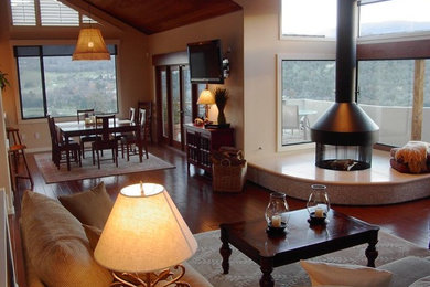 Foto de salón clásico renovado con suelo de madera en tonos medios, chimenea de esquina y marco de chimenea de piedra