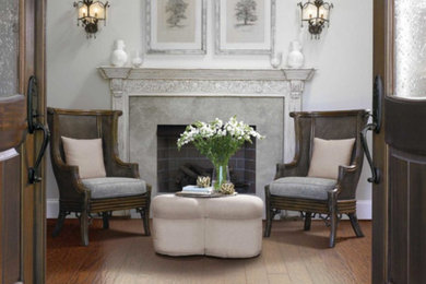 Photo of a small classic formal enclosed living room in Other with grey walls, dark hardwood flooring, a standard fireplace, a stone fireplace surround, no tv and brown floors.