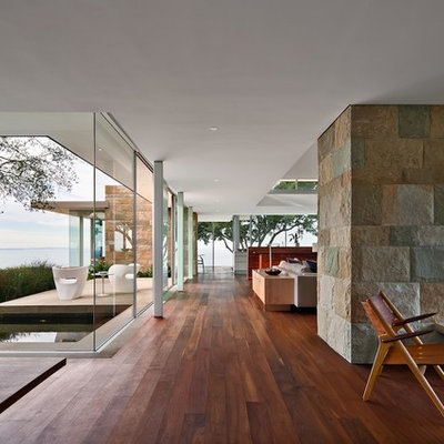 Example of a minimalist open concept living room design in Santa Barbara with a two-sided fireplace
