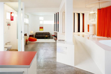 Imagen de salón para visitas abierto actual de tamaño medio sin chimenea y televisor con paredes blancas y suelo de cemento