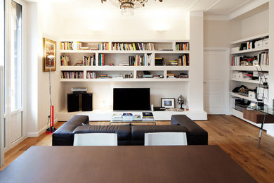 Idee per un soggiorno moderno con libreria, pareti bianche, parquet chiaro e TV autoportante