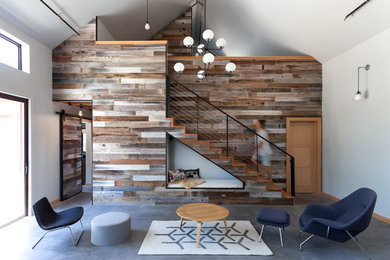 Immagine di un piccolo soggiorno design stile loft con pareti grigie, pavimento in cemento e nessuna TV