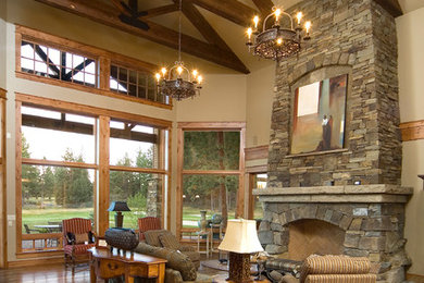 Mountain style living room photo in Other with a stone fireplace