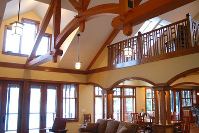 Example of an arts and crafts loft-style medium tone wood floor living room design in New York with yellow walls, a standard fireplace and a stone fireplace