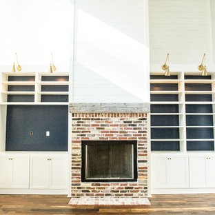Living room - loft-style medium tone wood floor living room idea in Atlanta with a brick fireplace and a media wall