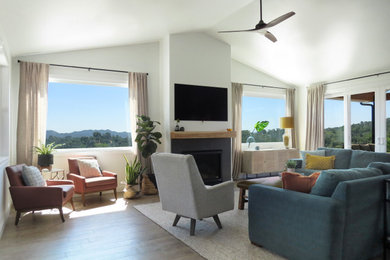 Großes, Offenes Modernes Wohnzimmer mit beiger Wandfarbe, dunklem Holzboden, Kamin, TV-Wand und gewölbter Decke in San Luis Obispo