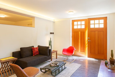 На фото: маленькая гостиная комната в современном стиле с белыми стенами и черным полом для на участке и в саду с