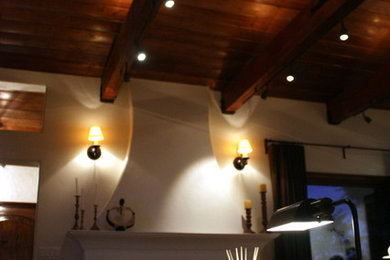 Ejemplo de salón para visitas cerrado mediterráneo de tamaño medio con paredes blancas, suelo de madera en tonos medios, todas las chimeneas, marco de chimenea de baldosas y/o azulejos y pared multimedia