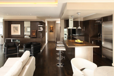 Идея дизайна: парадная, открытая гостиная комната среднего размера в стиле модернизм с темным паркетным полом, двусторонним камином, фасадом камина из дерева и коричневым полом без телевизора