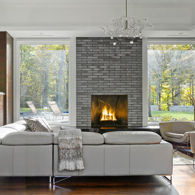 Large trendy formal and open concept laminate floor living room photo in Burlington with a standard fireplace, a brick fireplace, a wall-mounted tv and multicolored walls
