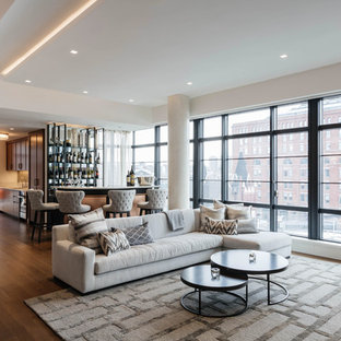 Idee per un soggiorno contemporaneo di medie dimensioni e aperto con angolo bar, pareti beige, parquet scuro, camino sospeso, cornice del camino in pietra, TV a parete e pavimento marrone