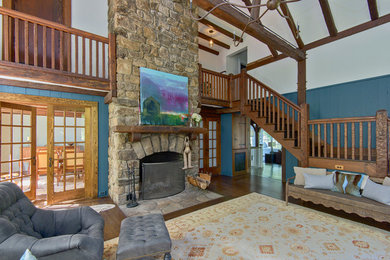 Large mountain style open concept carpeted living room photo in New York with blue walls, a ribbon fireplace and a stone fireplace